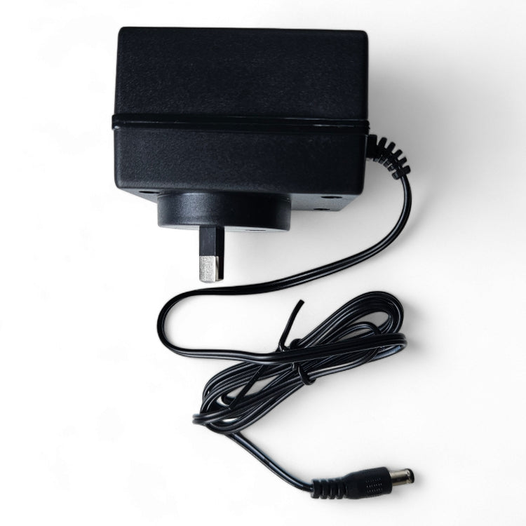Black wall plug power adapter with coiled cable and barrel connector.