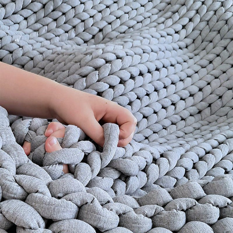 Hand reaching into a textured gray woven basket