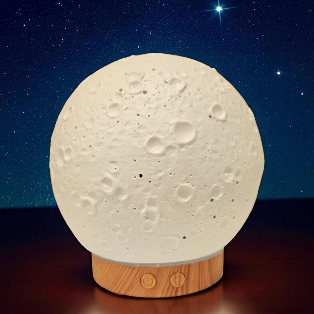 Moon-shaped lamp with wooden base against a starry night sky