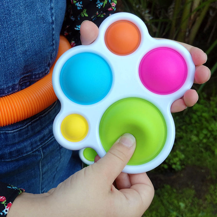 Colorful fidget toy held by a person outdoors
