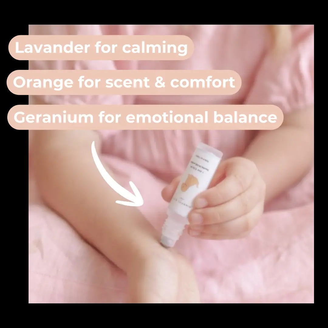 Baby holding a bottle with text about essential oils on a pink background