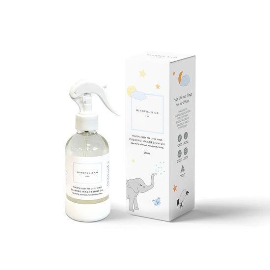 A bottle of Calming Magnesium oil next to its packaging box, which features an illustration of a sleeping child and stars.