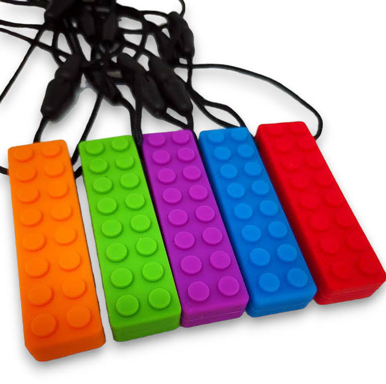 A selection of chew necklaces in various colors including orange, green, purple, blue, and red, with a textured block design.