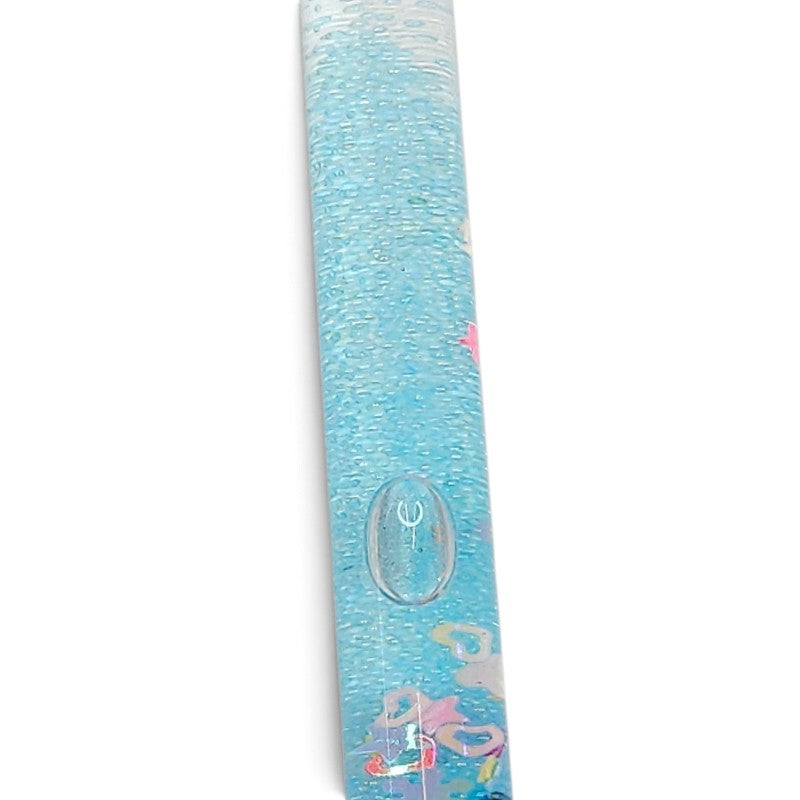 Close-up of a light blue glitter sensory wand showing the clear oval detail and colourful confetti inside.