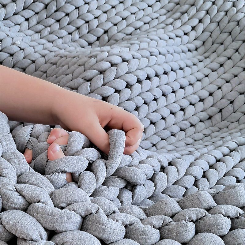 Hand reaching into a textured gray woven basket