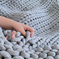 Hand reaching into a textured gray woven basket