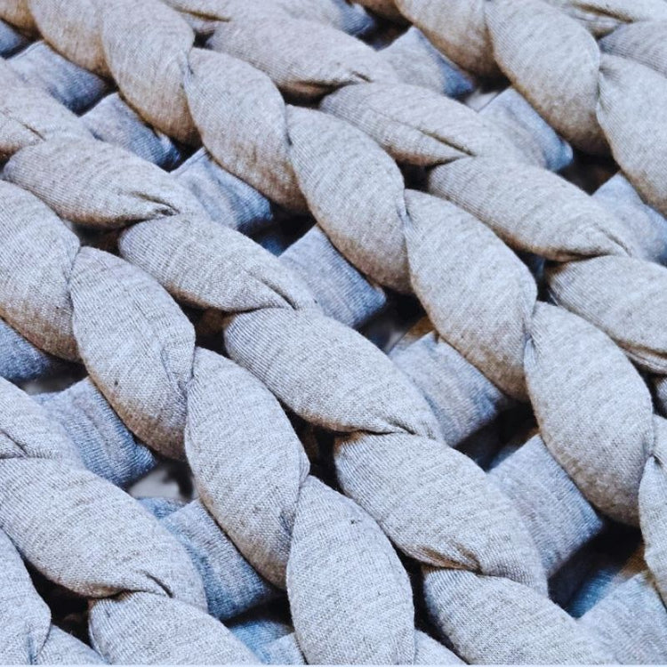 Close-up of woven fabric with braided pattern in gray and blue tones.