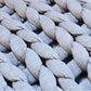 Close-up of woven fabric with braided pattern in gray and blue tones.