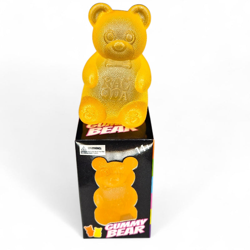 Yellow gummy bear toy on top of a black box with &