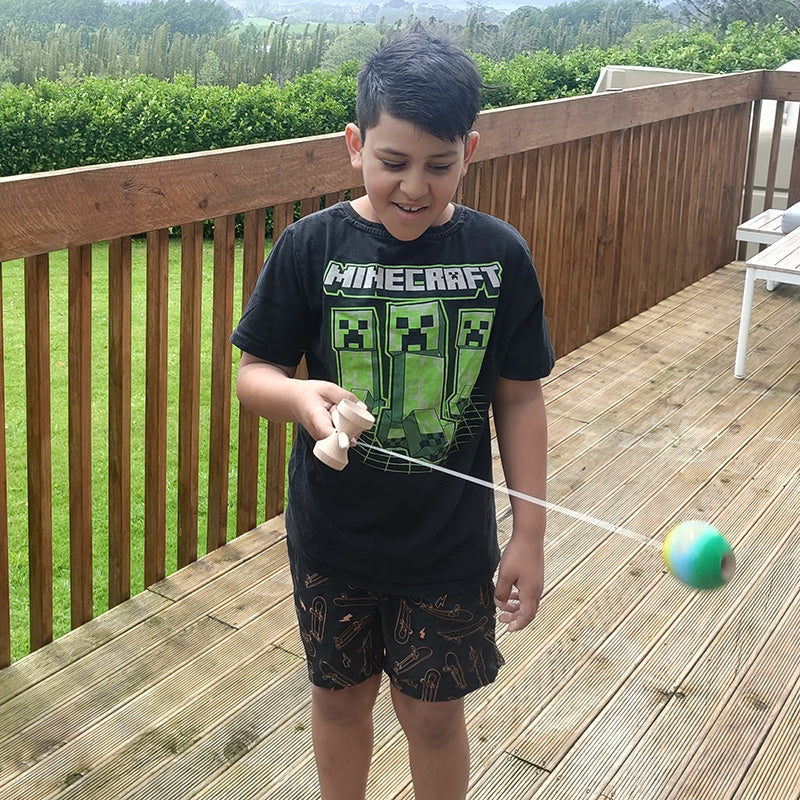 Child playing with a ball on a wooden deck