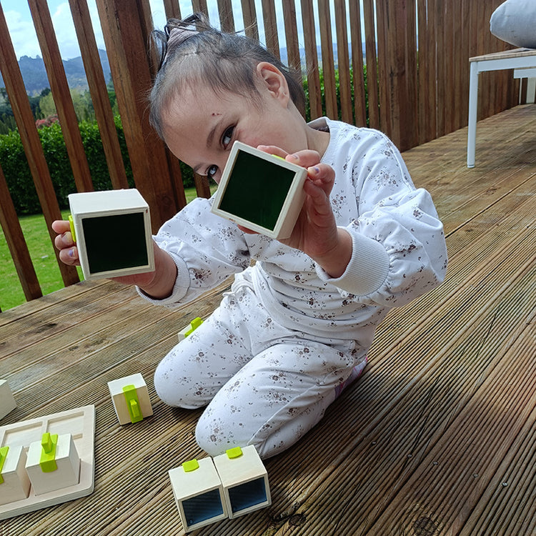 Child playing with building blocks on a wooden deck