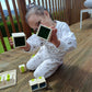 Child playing with building blocks on a wooden deck