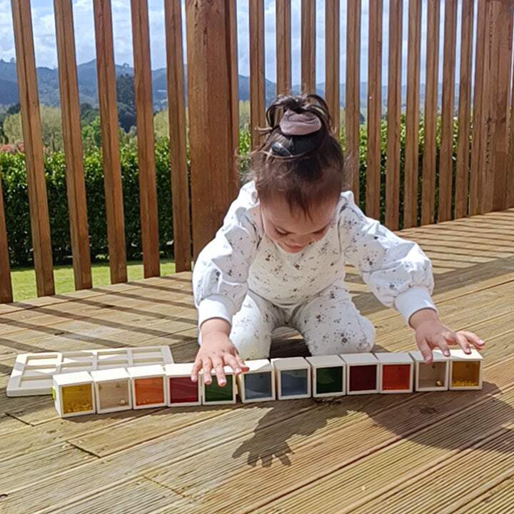 Child playing with colorful blocks on a wooden deck