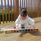 Child playing with colorful blocks on a wooden deck