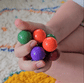 Child holding colourful Proton Fidget Balls in animated close-up