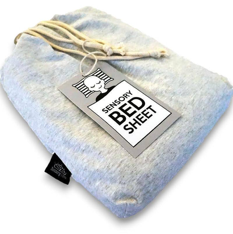 A grey sensory bed sheet made of cotton and spandex with a label attached showing the brand and product name.
