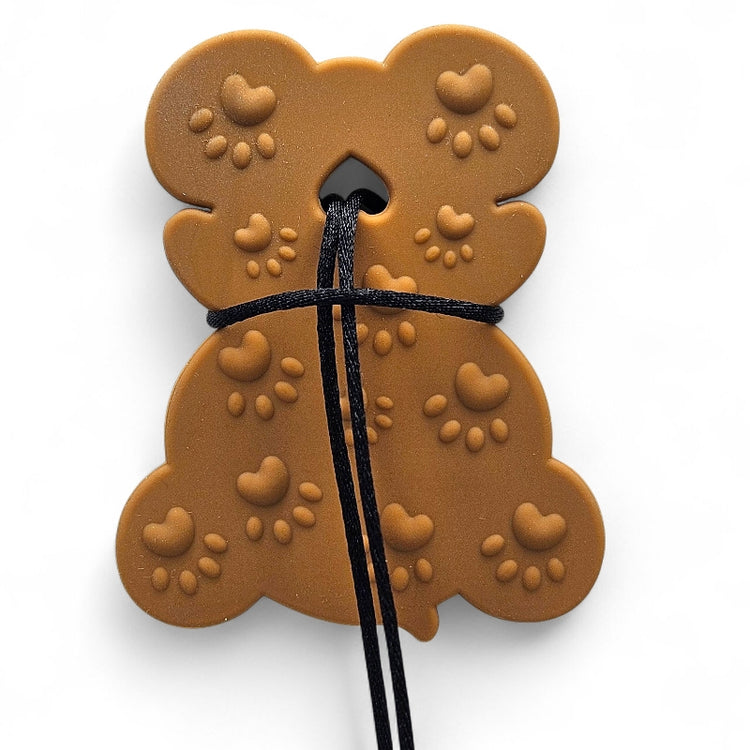Brown dog treat shaped like a bone with heart patterns on a white background