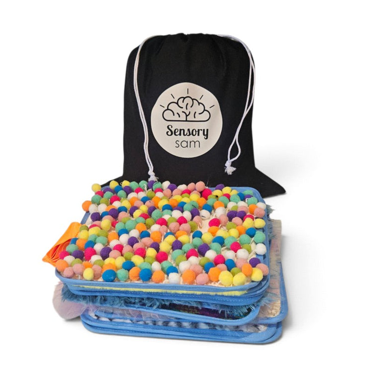 Texture Discovery Book pages stacked with a colourful pom-pom page in front of a black Sensory Sam drawstring bag.