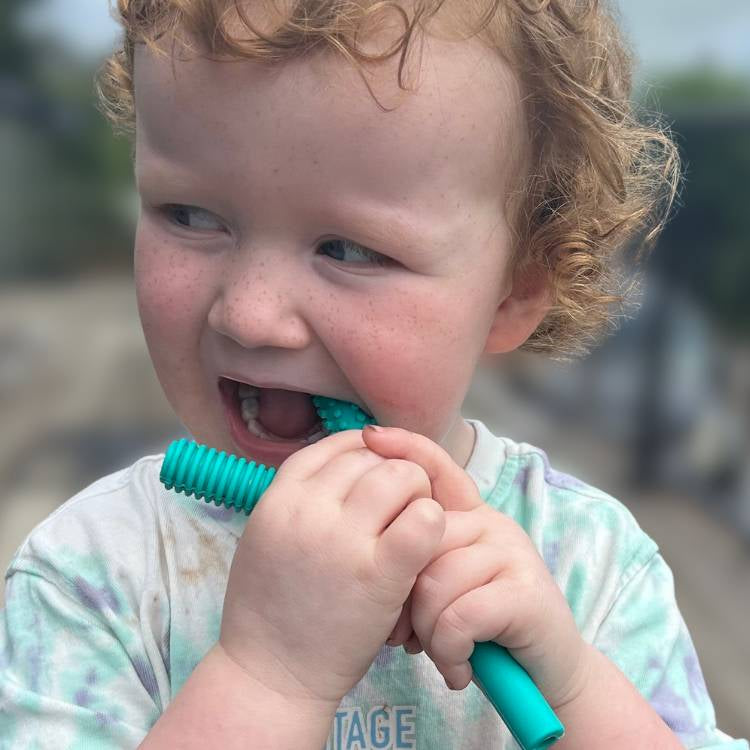 Child playing with a blue toy outdoors