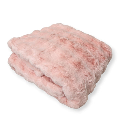 A folded pink weighted blanket with a bumpy fur texture on a white background.