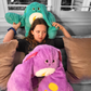 Child seated with green and purple weighted monster plush toys