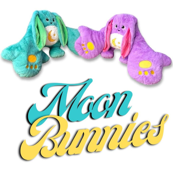 Two plush toys designed as moon bunnies in blue and purple colors, with a text overlay reading &