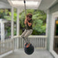 Child on a swing set with a blurred garden background