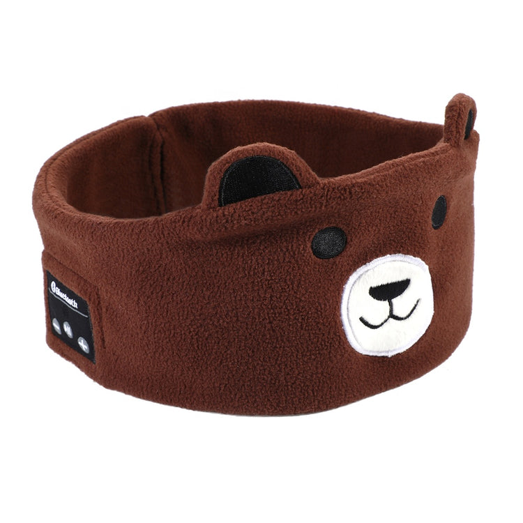 A child wearing a brown pair of ear muffs with a bear design on the top, connected to a device via a 3.5 mm cable.