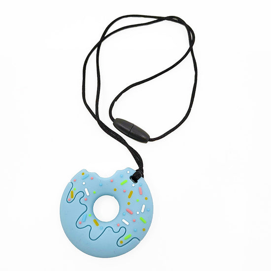 A chewable necklace with a blue donut-shaped pendant with multicolored sprinkles, attached to a black cord with a breakaway clasp.