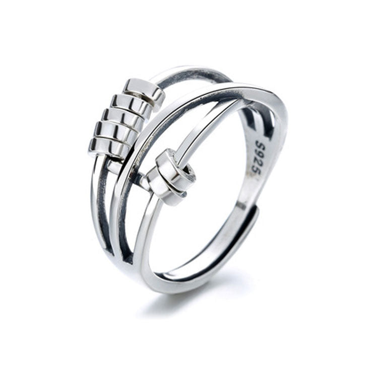 A sterling silver fidget ring with movable beads on a finger, showing a polished silver finish.