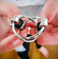A close-up of a stainless steel fidget toy with silicone rubber rings being held between fingers.