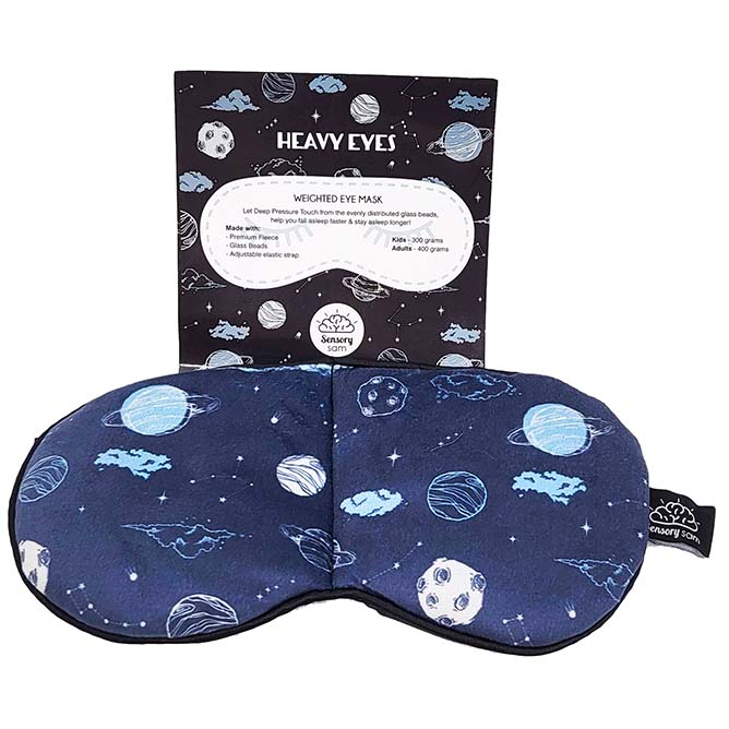 Weighted sleep mask with a space-themed pattern, including planets and stars, displayed alongside its packaging.