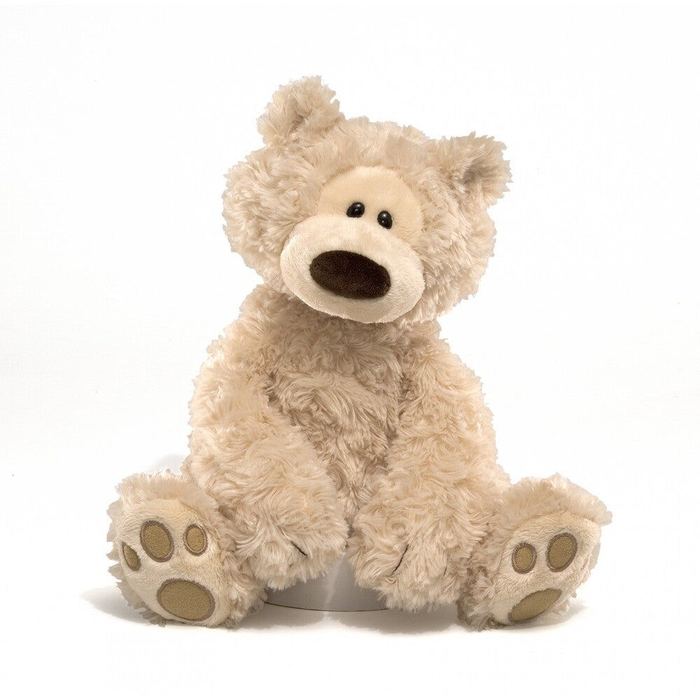 A beige plush toy bear with a soft, furry texture. It has a simple, friendly face with a small mouth and black eyes, and its hands are outstretched.