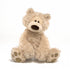 A beige plush toy bear with a soft, furry texture. It has a simple, friendly face with a small mouth and black eyes, and its hands are outstretched.