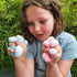 A child holding two pocket-sized sensory stress balls in blue and pink colors.