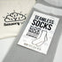 Packaging of Sensory Sam seamless socks in grey with a white band, displaying the product name and emphasizing no heel and seamless technology.
