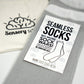 Packaging of Sensory Sam seamless socks in grey with a white band, displaying the product name and emphasizing no heel and seamless technology.