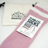 A two-pack of pink seamless socks with a rose design and a white band, labeled &