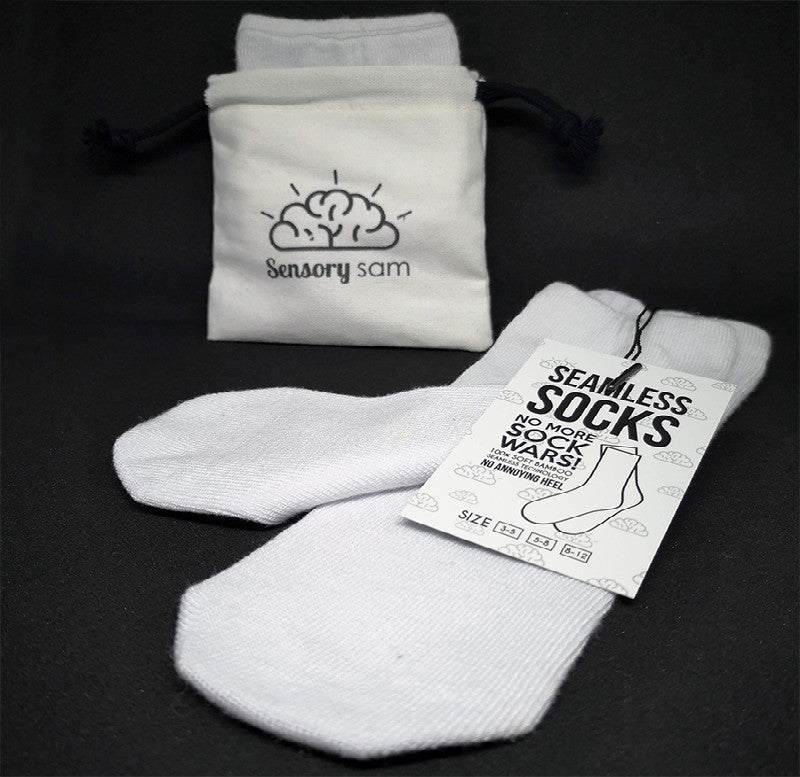 A pair of white, seamless socks made from bamboo, displayed next to their packaging which reads &