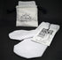A pair of white, seamless socks made from bamboo, displayed next to their packaging which reads &