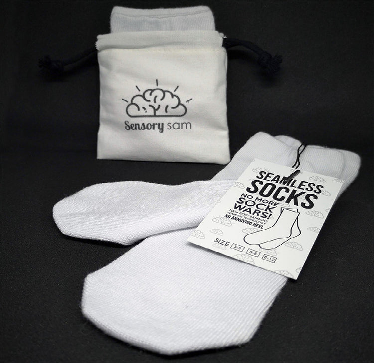 A pair of white, seamless socks made from bamboo, displayed next to their packaging which reads &