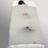 A gray sensory bed sheet made of Lycra/Spandex, packaged and tied with a string, with a product tag attached.