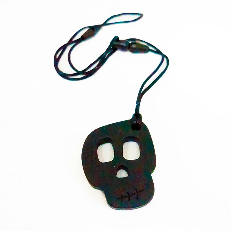 A silicone skully pendant necklace with a breakaway cord, primarily black in color with a textured design.