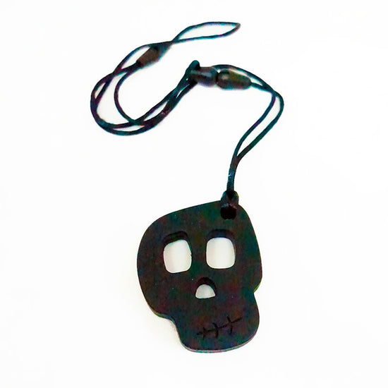 A silicone skully pendant necklace with a breakaway cord, primarily black in color with a textured design.
