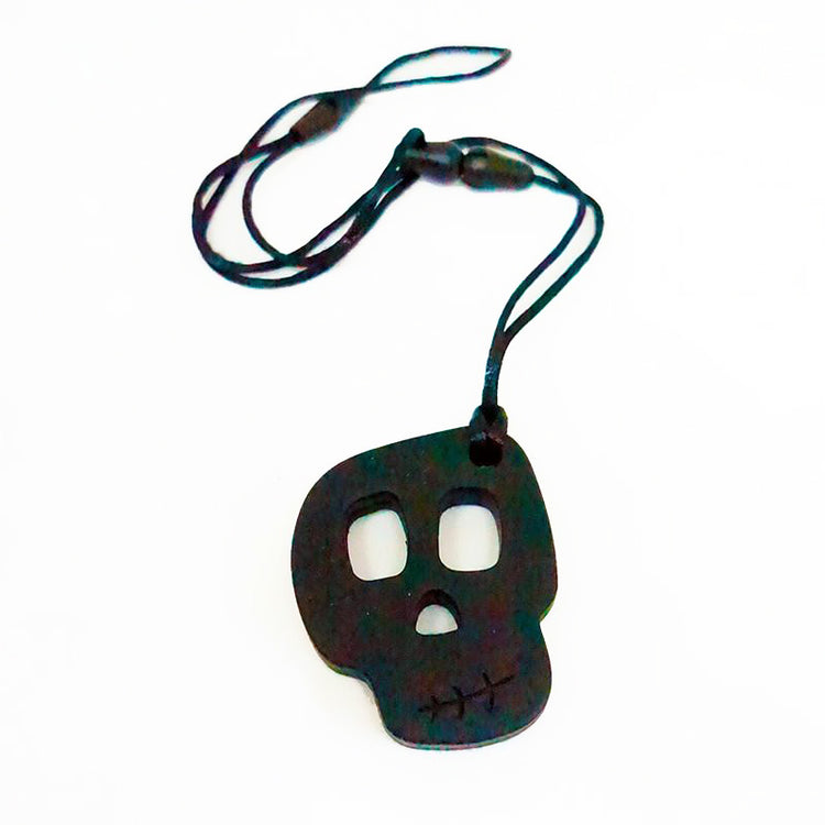 A silicone skully pendant necklace with a breakaway cord, primarily black in color with a textured design.