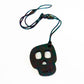 A silicone skully pendant necklace with a breakaway cord, primarily black in color with a textured design.
