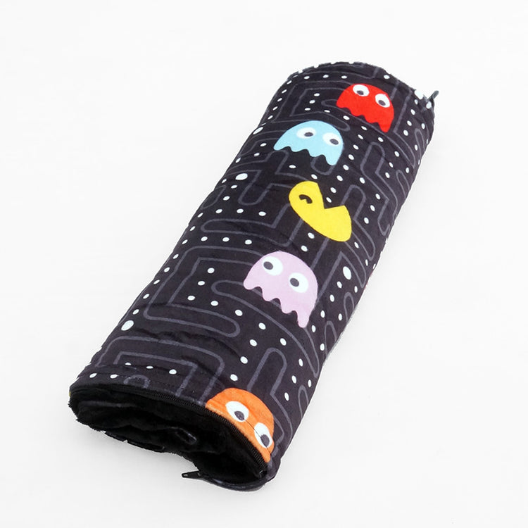 A rolled-up weighted lap pad with a black background featuring colorful pac-man style ghosts pattern.